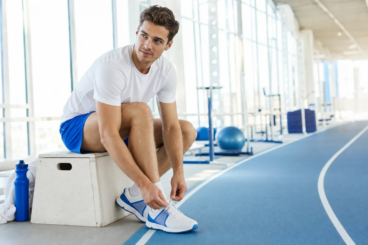 An athlete calmly preparing her shoes before an indoor fitness race